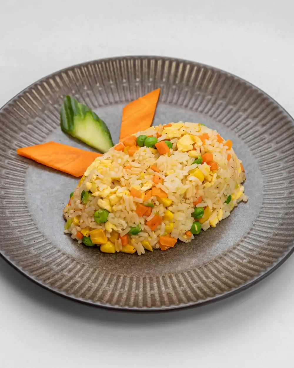 A bowl of egg fried rice with sweetcorn, peas, carrot and spring onion